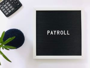 Payroll sign board and calculator on white background. Payroll concept