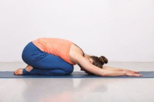 Woman relax in Hatha yoga asana Balasana child pose