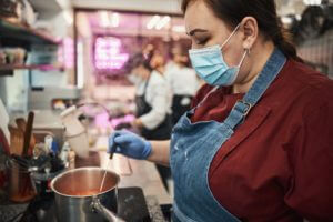 Professional kitchen staff following food handling safety protocols