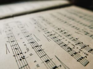 Close-up image of an old book with music notes. Sheet music with notes and lyrics