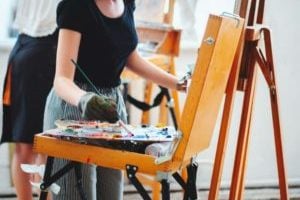 Artist mixing oil painting on wooden palette