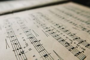 Close-up image of an old book with music notes. Sheet music with notes and lyrics