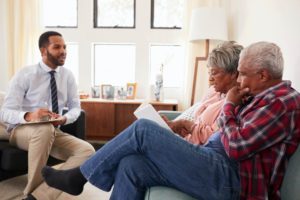 Senior Couple Meeting With Male Financial Advisor At Home